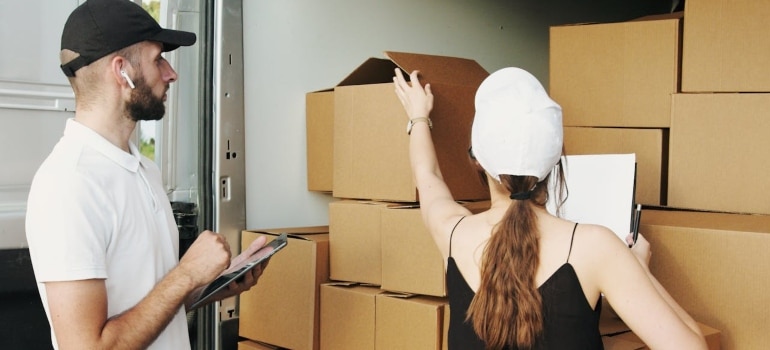 a man and a woman checking some boxes