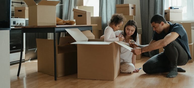 A family of three packing boxes before leaving them in storage in Aspen
