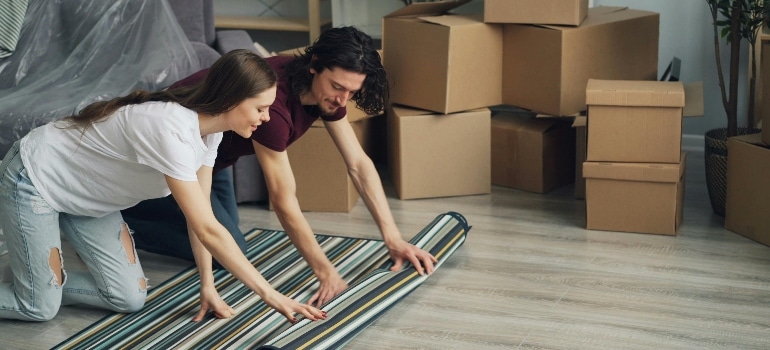 a couple rolling a rug