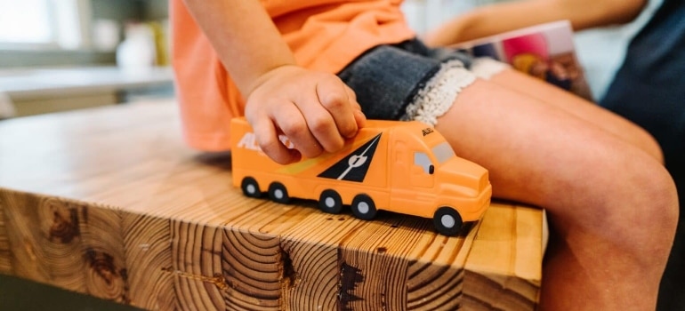 a kid playing with a truck toy