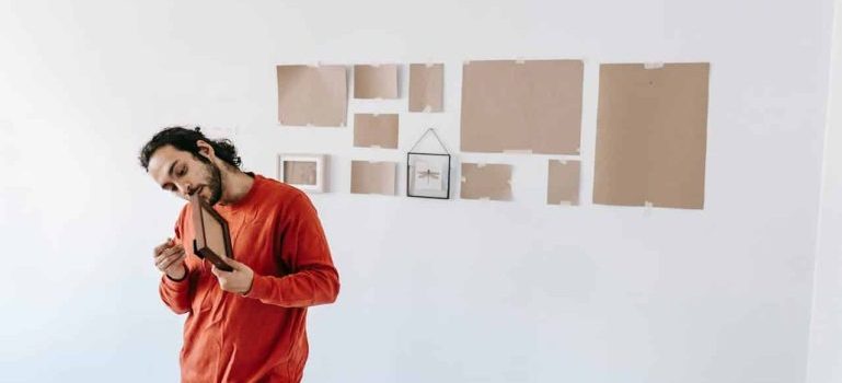 man holding wall decoration