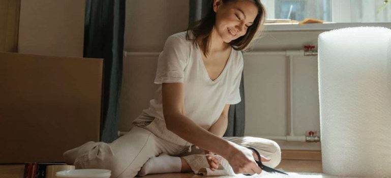 woman preparing bubble wrap after reading about The Best Way to Pack Wall Art for Moving