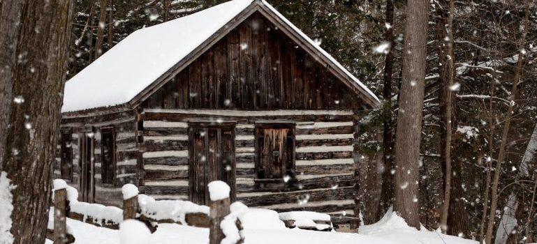 snowy brown house near trees