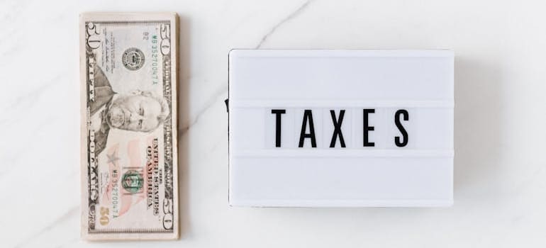 dollar bills and vintage light box with inscription "Taxes"