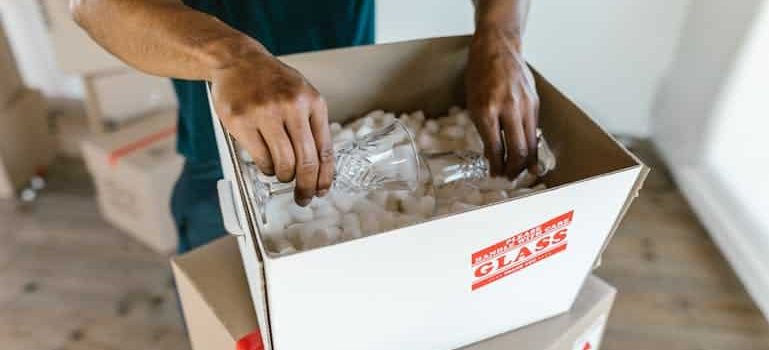 a mover packing antique glasses in a box