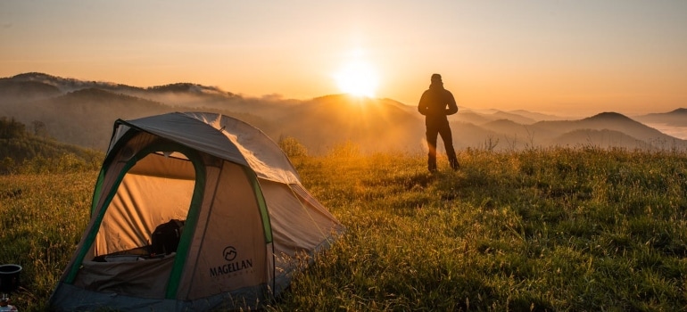 Silhouette of Person Standing Near Camping Tent