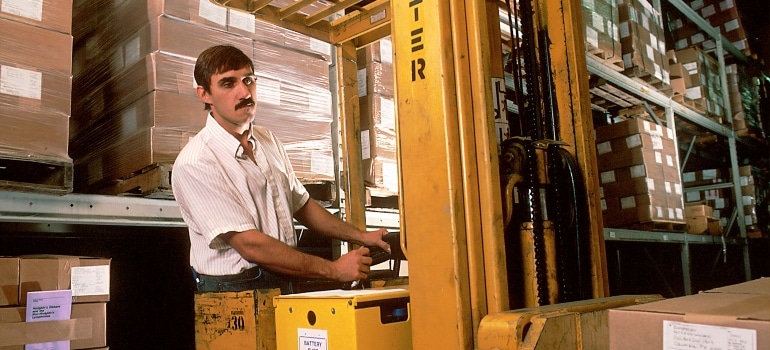 A man in Roaring Fork storage driving forklift