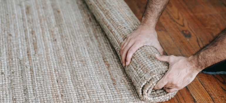 A person rolling a carpet