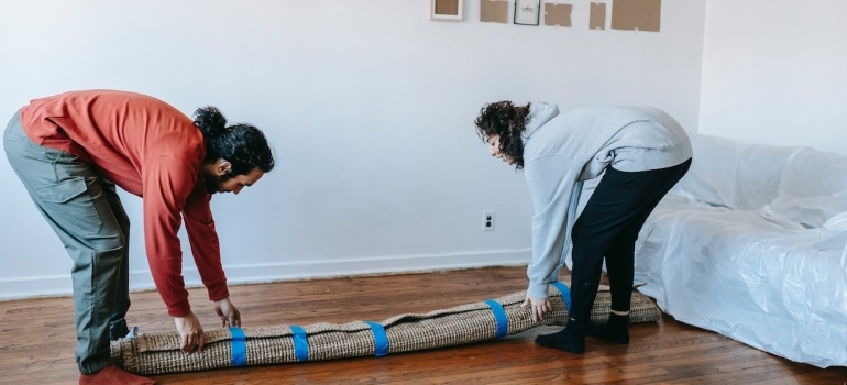 a couple moving rugs and carpets