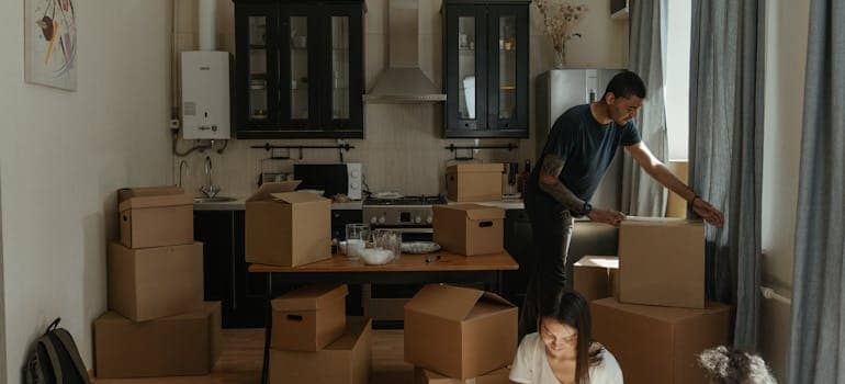 a couple packing a kitchen