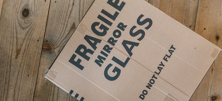 cardboard box labelled "fragile mirror glass, do not lay flat"