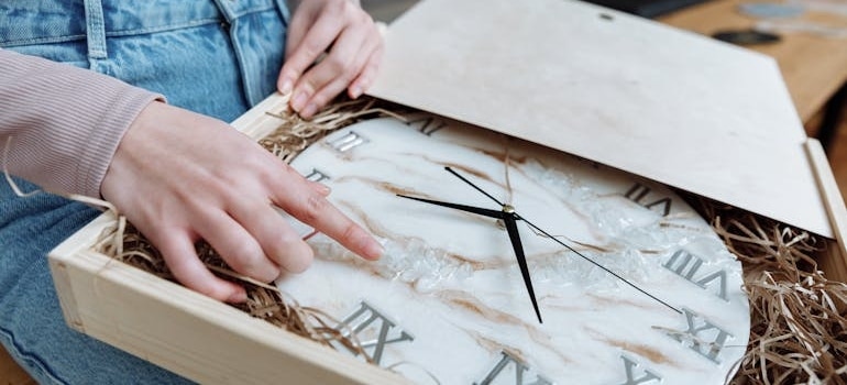a woman taking a clock from the box